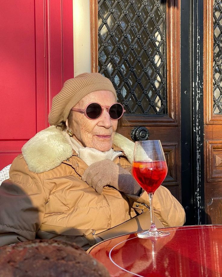 glamorous elderly woman sipping on a fancy beverage